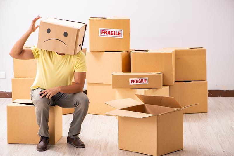 Unhappy man stressed about moving all these boxes to his new home