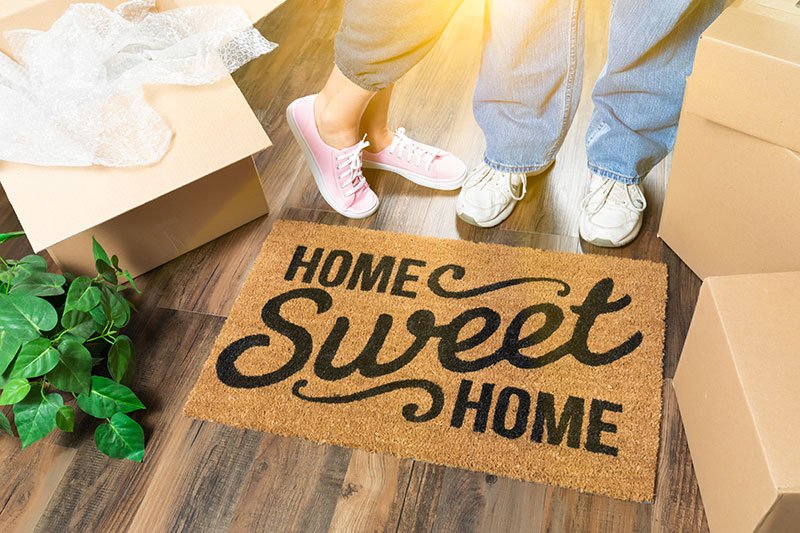 A couple placing their doormat after a successful move